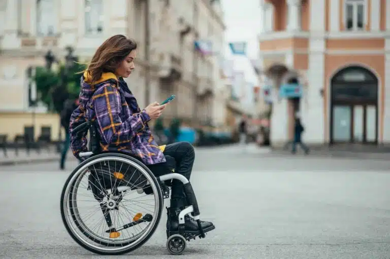 woman with disability using a smartphone while out in the city